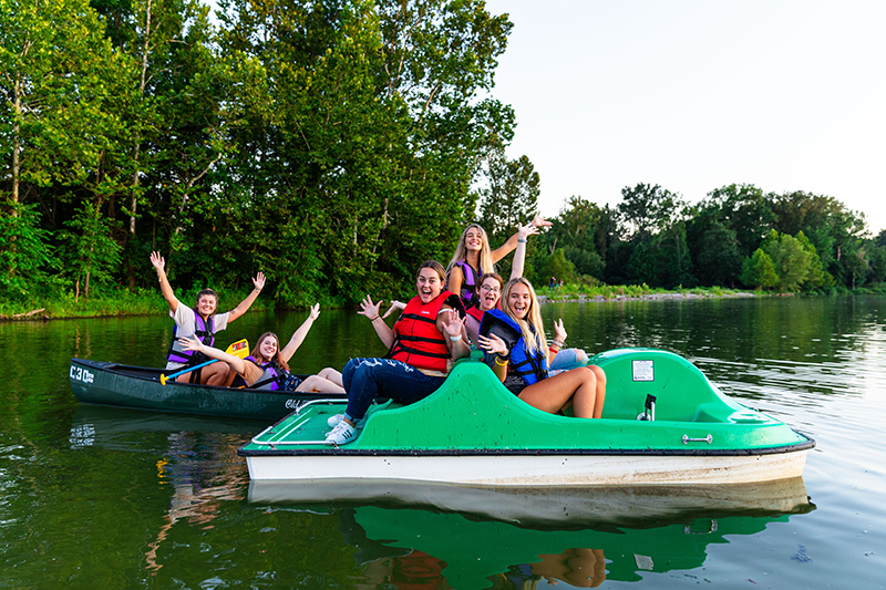 SIU students wave from a couple of boats on Campus Lake