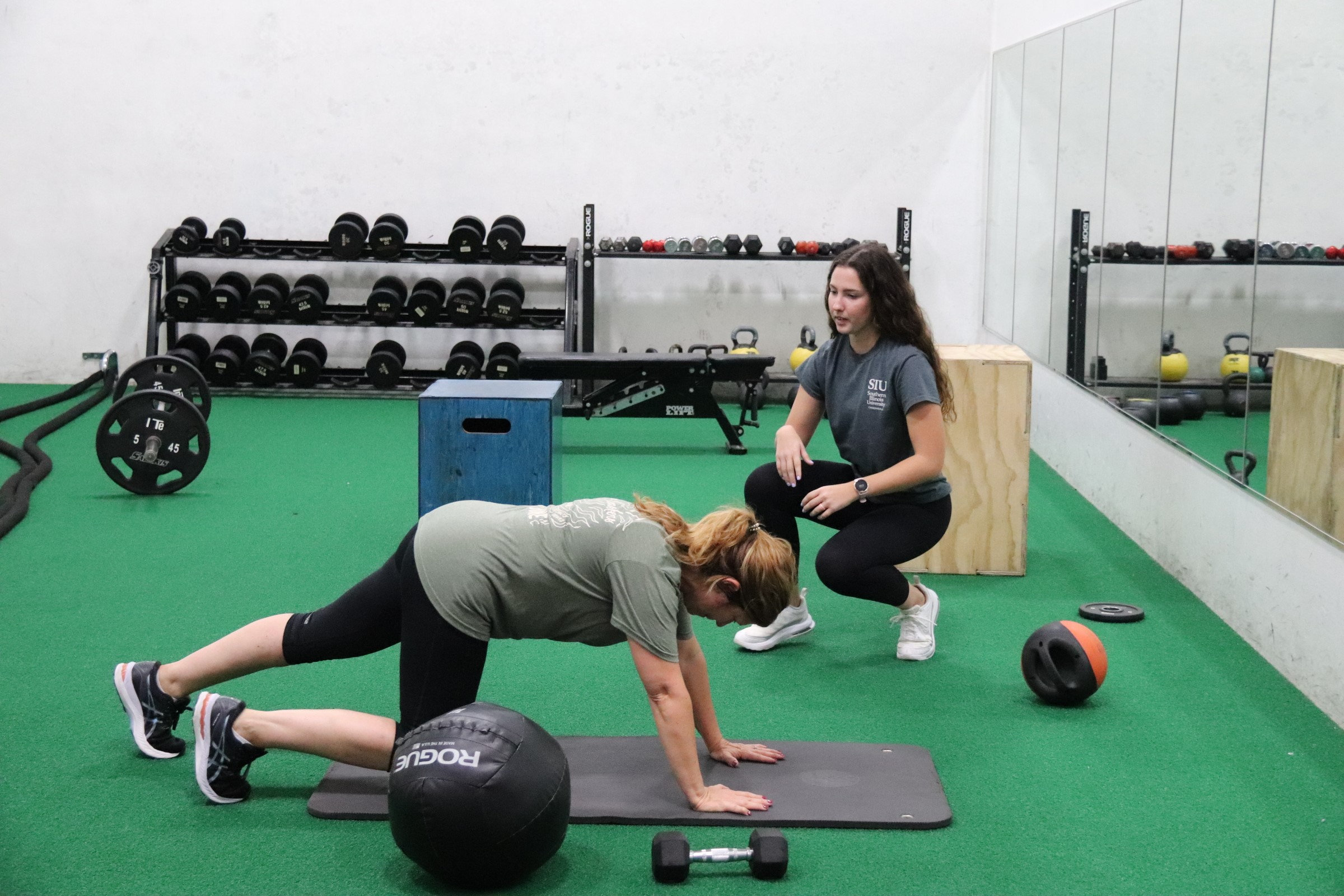 Personal trainer works with a client in the fitness room