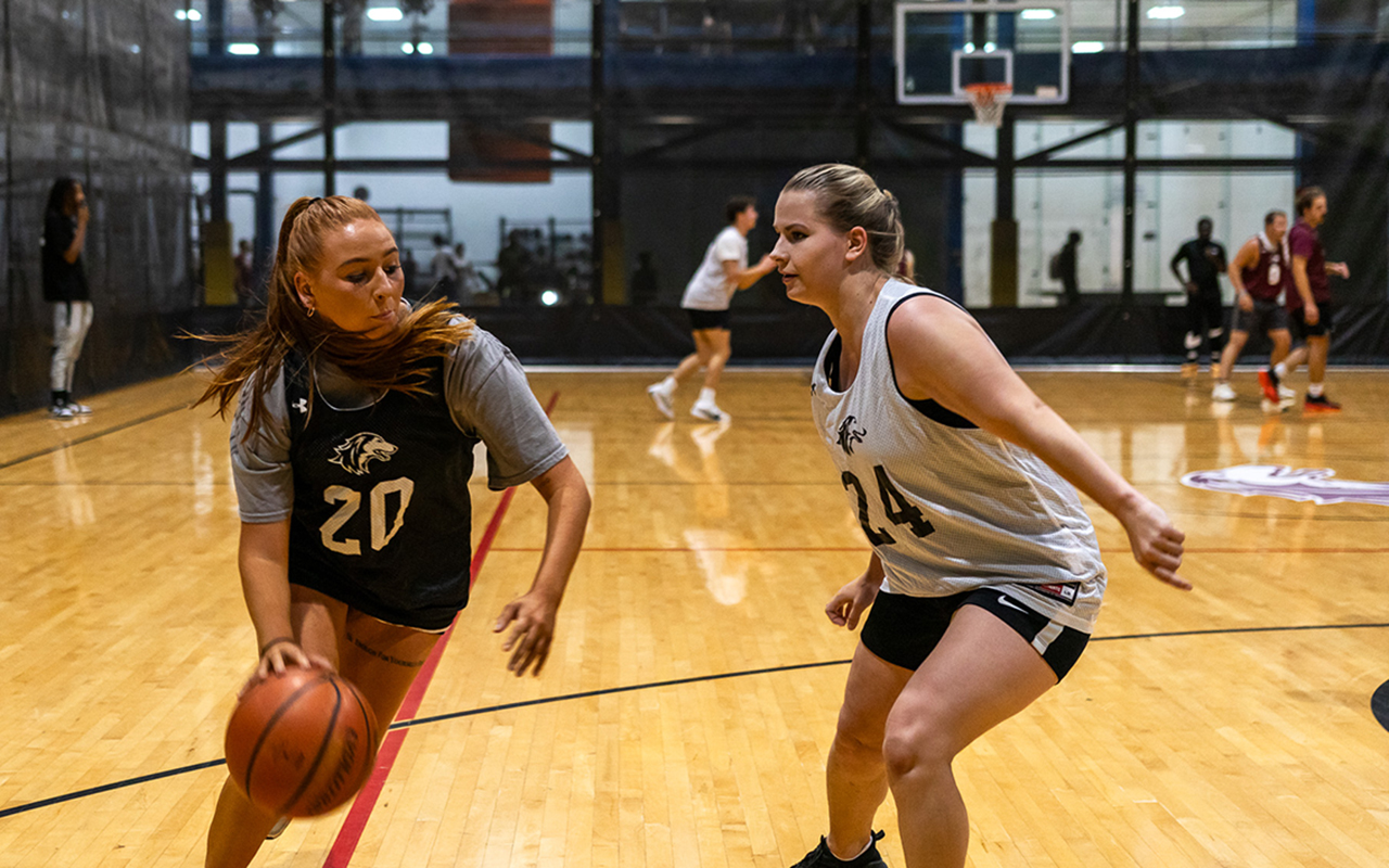 SIU student drives basketball to the hoop with a defender